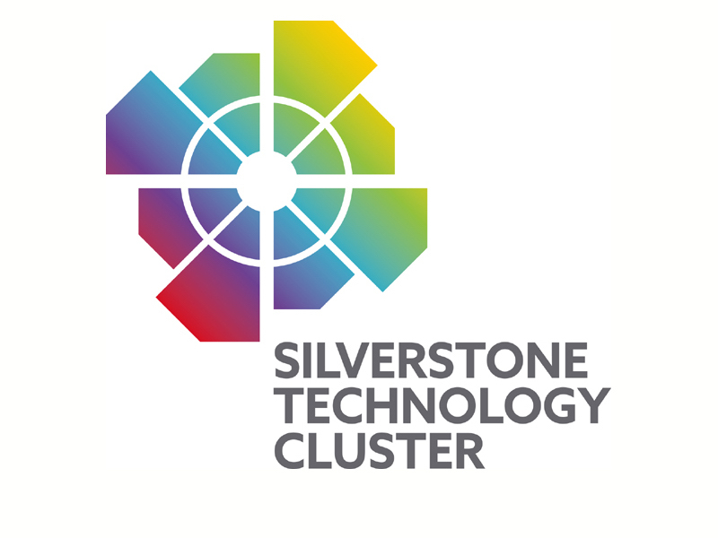 Logo of Silverstone Technology Cluster featuring a geometric design with intersecting lines and polygonal shapes in a gradient of colors including red, yellow, and blue, next to the text "Silverstone Technology Cluster.